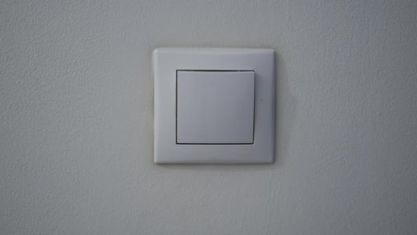 Fechar a mão do homem desligando a luz de um interruptor de parede — Vídeo de Stock