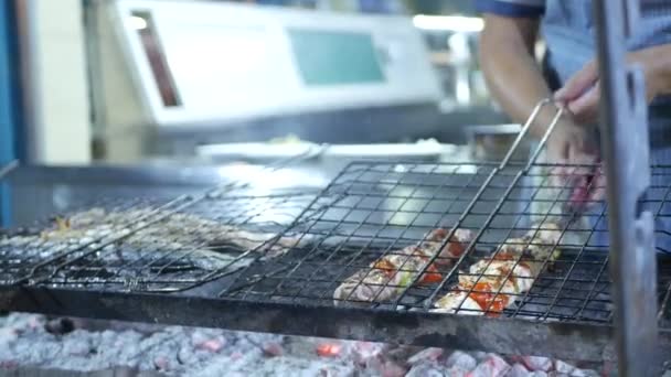 Restaurantbild mit einem Koch, der einen Grill mit Fisch und Meeresfrüchten zubereitet — Stockvideo