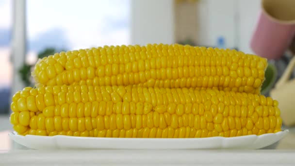 Söt gul majs färsk kokt och varm på en tallrik på lunch bord i köket — Stockvideo