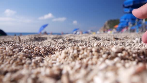Розслаблений турист в відпустку грати і беручи з рук пісок з пляжу — стокове відео