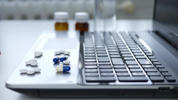Homem sofrendo no escritório Selecione e coloque em ordem pílulas médicas na superfície do laptop — Vídeo de Stock