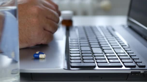 Zakenman in Office stoppen met het werken met laptop en neem medische pillen met water — Stockvideo