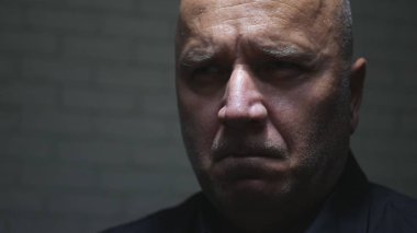 Gergin yüz ifadesi ile bir karanlık yerde adam portre üzgün