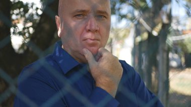 Hayal kırıklığına kişi koruma bölgesi'metal çit arkasında düşünceli düşünme