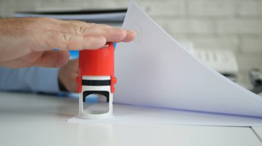 Manager Stamping Some Papers and Documents Using a Rubber Stamp in Slow Motion clipart