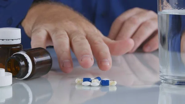 Pessoa sofredora tomar pílulas da mesa para um tratamento médico — Fotografia de Stock