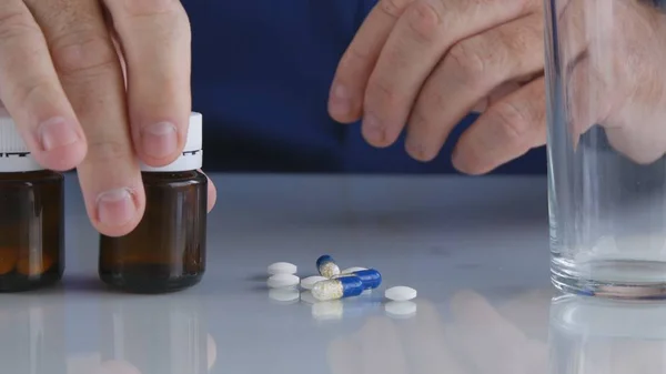 Pessoa sofredora tomar pílulas da mesa para um tratamento médico — Fotografia de Stock