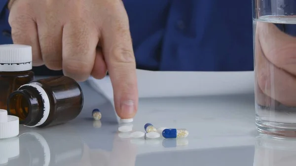 La persona que sufre toma pastillas de la mesa para un tratamiento médico — Foto de Stock
