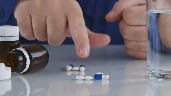 La persona que sufre toma pastillas de la mesa para un tratamiento médico — Foto de Stock
