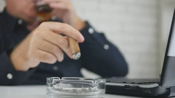 Businessman Blurred Image Drinking Whisky Smoking Cigar and Working on Laptop — Stock Photo, Image