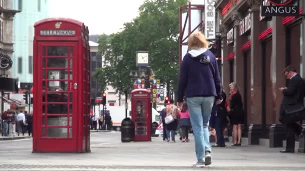 Изображение лондонской улицы Даунтаун-стрит с людьми, проходящими мимо красной телефонной будки — стоковое видео