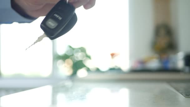 Человек держать в руке ключ автомобиля с пультом дистанционного управления отображается в камеру — стоковое видео