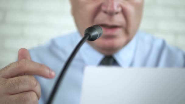 Уверенный бизнесмен говорит с микрофоном на конференции "Читая документ" — стоковое видео
