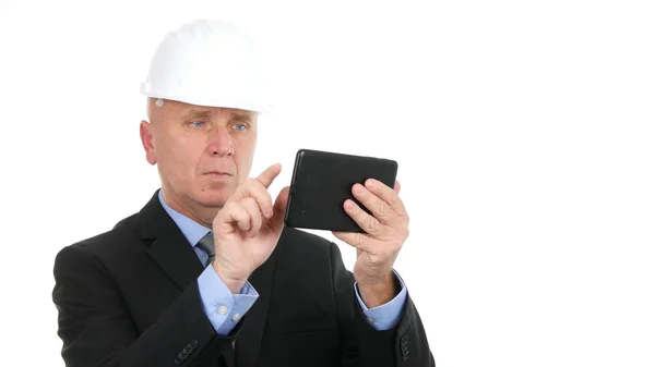 Εικόνα με τον επιχειρηματία να φοράει σκληρό καπέλο και να χρησιμοποιεί ηλεκτρονικό δισκίο — Φωτογραφία Αρχείου