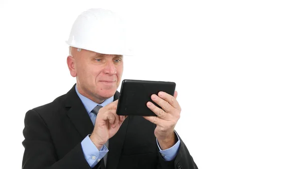 Homme d'affaires avec Hardhat sourire et texte à l'aide d'une tablette électronique — Photo