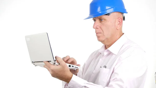 Súlyos mérnök olvas és ír műszaki üzenet használ egy laptop — Stock Fotó