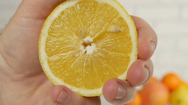 Imagem de perto com o homem espremendo o suco de uma fruta fresca de limão — Fotografia de Stock