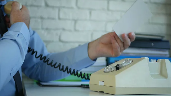 Image avec un homme d'affaires au bureau lisant un document au téléphone — Photo