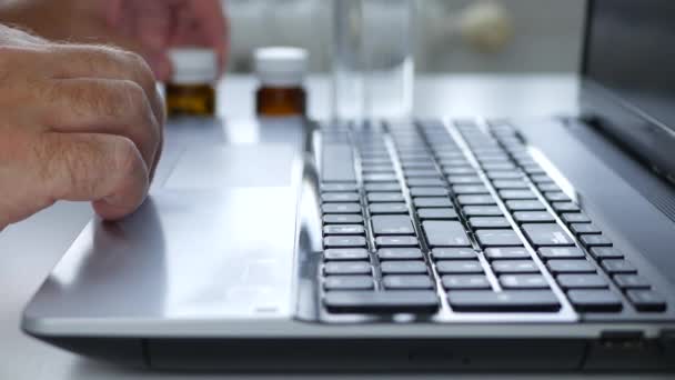 Souffrant homme d'affaires bouteille de médecine ouverte sur ordinateur portable et prendre quelques pilules médicales — Video