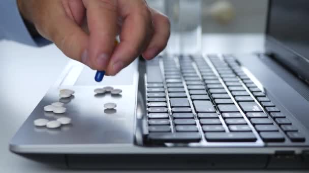 Der leidende Geschäftsmann im Büro wählt medizinische Pillen auf der Laptop-Oberfläche — Stockvideo