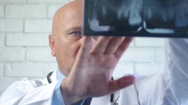 Imagen con un dentista preocupado mirando a una radiografía dental — Vídeo de stock