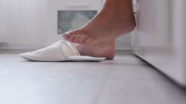 Hombre en el dormitorio bájate de su cama y toma las zapatillas — Vídeo de stock