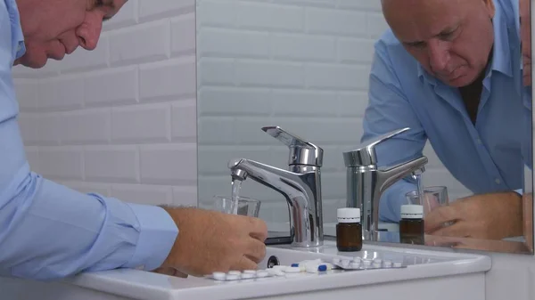 Бизнесмен, страдающий от сильной боли, принимает медицинские таблетки в ванной комнате — стоковое фото