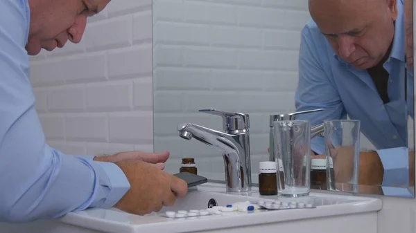 Üzletember a fürdőszobában Szöveg mobiltelefon és vegye orvosi tabletták — Stock Fotó
