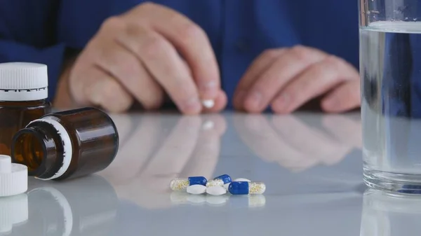 Imagen de primer plano con las manos del hombre tomando de la tabla píldoras médicas — Foto de Stock