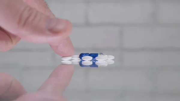 Man Select and Take Pills para um tratamento médico da mesa de vidro — Fotografia de Stock