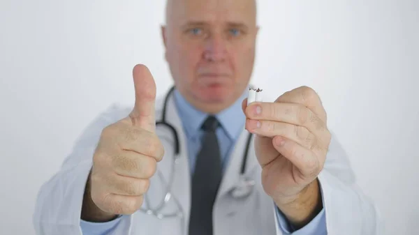 Lekarz w kampanii antytytoniowej złamać papierosa i zaleca rzucić palenie — Zdjęcie stockowe