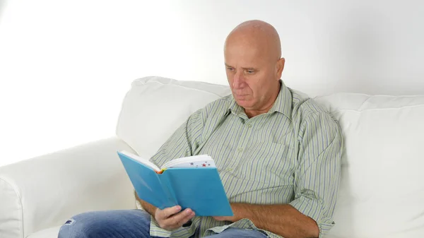Imagen con una persona relajada leyendo un libro en el sofá — Foto de Stock