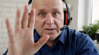 Bilgisayarlı Kamera ve Kulaklık kullanarak Evden Çalışan ve Konuşan Adam, Covid-19 Salgınıyla Sosyal Mesafe, Evden Uzaktan Çalışma