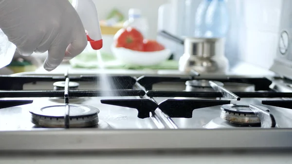 Busy Person in the Kitchen Wearing Gloves Cleans with Solution the Cooker Stove.