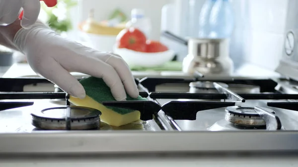 Busy Person in the Kitchen Wearing Gloves Cleans with Solution the Cooker Stove.