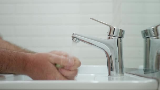 Mann im Badezimmer reinigt seine Hände mit Seife und sauberem Wasser desinfiziert Haut von Viren und Bakterien — Stockvideo