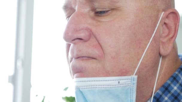 Mężczyzna z maską chirurgiczną na twarzy dymi papierosa zrelaksowany — Wideo stockowe