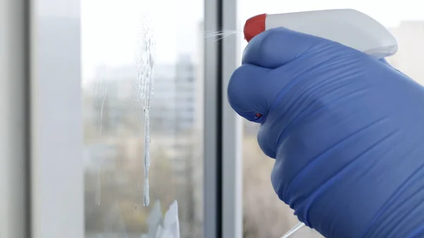 Close Up Man Ręce z rękawicami ochronnymi Czyszczenie okna przy użyciu spryskiwanego płynu dezynfekującego przed wirusami — Zdjęcie stockowe