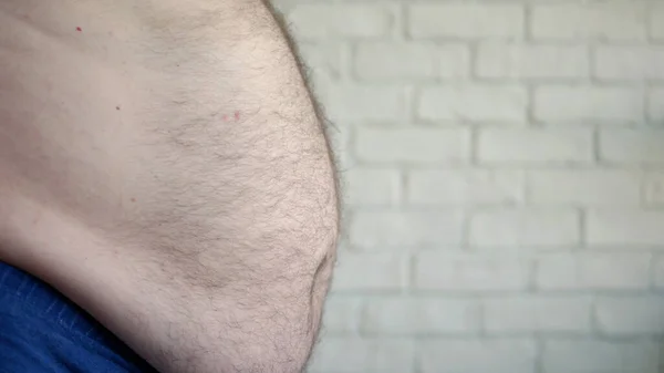L'uomo obeso che mostra la sua pancia grassa, una persona affamata che misura il suo grasso della pancia, problemi di salute di un vecchio con obesità — Foto Stock