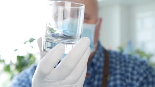 Bartender med Protection Face Mask och handskar i händerna Tvätta och rengöra ett glas — Stockvideo