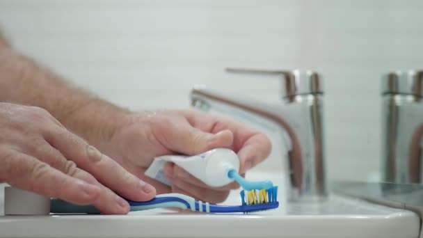 Zeitlupenmensch Badezimmer Legt Zahnpasta Auf Die Zahnbürste Und Putzt Sich — Stockvideo