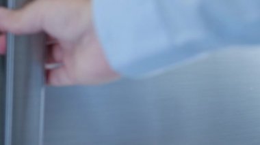 Susamış adam boş buzdolabını açar ve içecek arar. Soğuk ve taze suyla bir şişe alır.