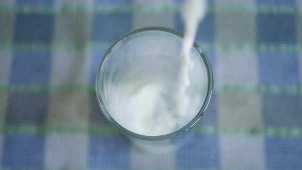 Image rapprochée avec remplissage d'un verre de lait frais et délicieux au petit déjeuner — Video