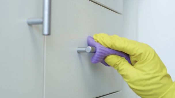 Gros plans L'homme porte des gants de protection blancs pour la maison Nettoie et désinfecte les meubles de cuisine et de salle de bain — Video