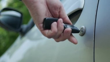 Sürücü arabanın kilidini açar, arabanın kapısını açar ve sürücü koltuğuna oturur.