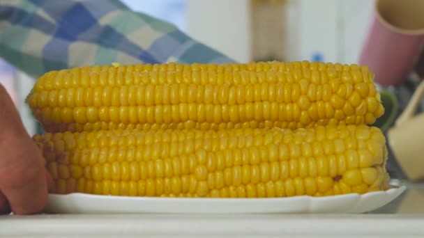 Man Presenteert een plaat vol met hete gekookte maïs in de keuken, een verse en smakelijke gezonde maaltijd — Stockvideo