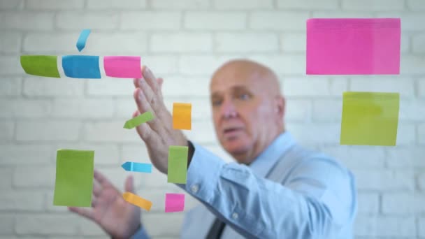 Imagem turva com um empresário conversando e gesticulando na parte de trás de uma placa transparente com notas adesivas coloridas — Vídeo de Stock