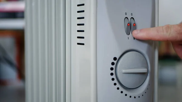 Man, Soğuk Oda 'da Elektrikli Radyatörün Isıtma Sıcaklığını Ayarladı