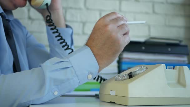 Imagen con un hombre de negocios en la sala de oficina de pie y hablando por teléfono usando una vieja tecnología de comunicación — Vídeo de stock