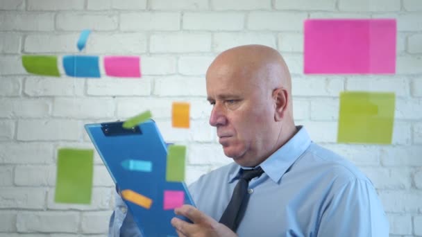 Uomo d'affari che fa un piano dietro una scheda trasparente con note adesive colorate — Video Stock